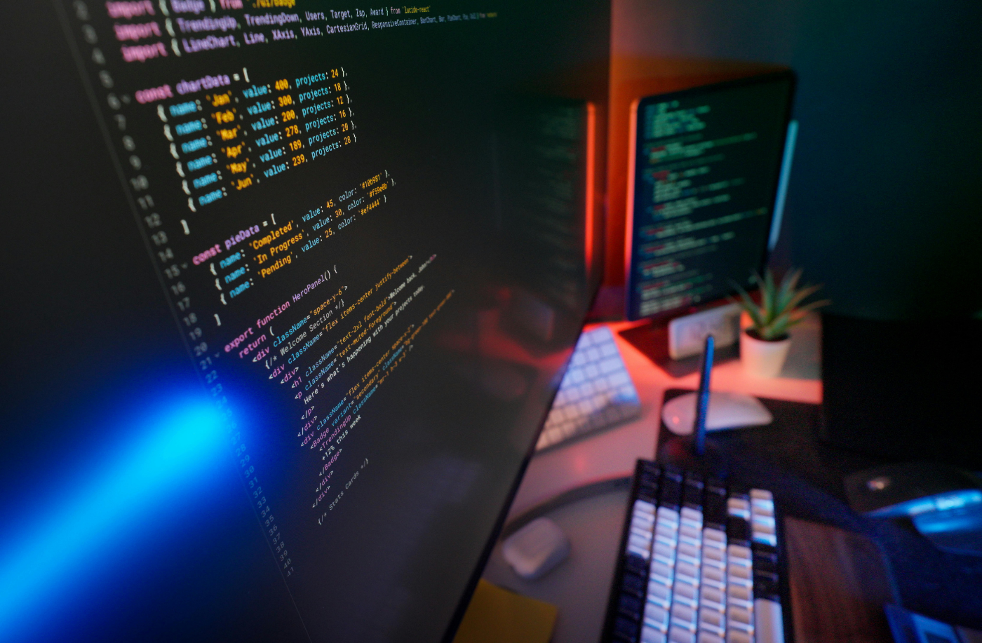 A developer's workstation with code on screen in a dimly lit office